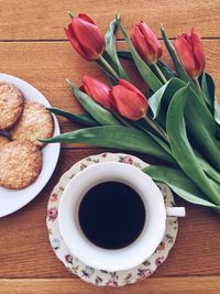 High angle view of coffee and biscuits with tulips on table