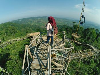 Rear view of woman standing on structure 