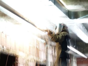 Blurred motion of man seen through glass window