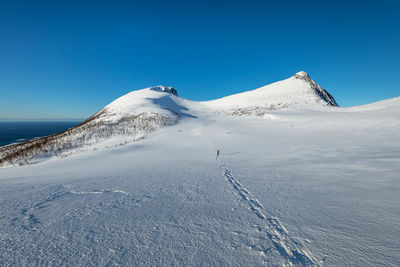 Scenic view of snowcapped mountains against clear blue sky