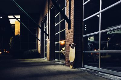 Rear view of man walking on illuminated street at night