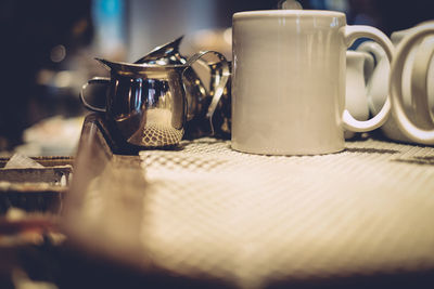 Close-up of cups and jugs on table at restaurant