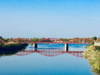 Arch bridge over river against clear sky