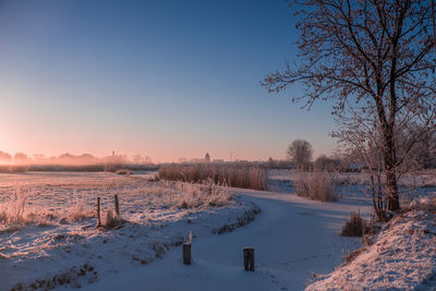 Scenic view of snow field against sky during sunset