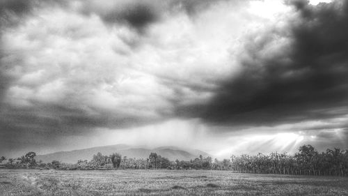 Scenic view of field against cloudy sky