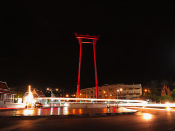 Illuminated light trails in city against sky at night