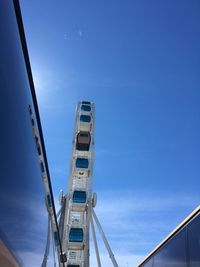 Low angle view of ferris wheel against blue sky