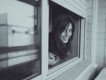 Portrait of woman leaning on window sill