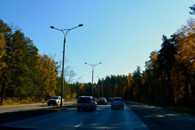 Cars on street against clear sky