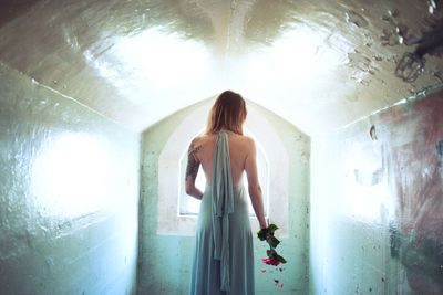 Rear view of woman standing at home