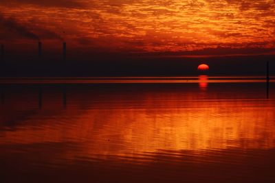 Scenic view of lake against orange sky