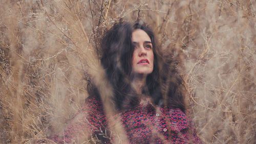 Close-up of thoughtful woman resting on plants