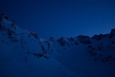 Scenic view of snowcapped mountains against clear blue sky