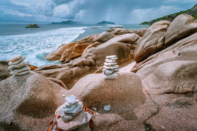 Stack of rocks on beach against sky