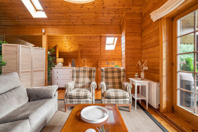 Beautiful interior of cozy living room with sofa and armchairs in a wooden house. life in a village