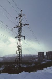 Low angle view of electricity pylon against clear sky