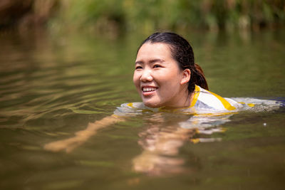 Swimming woman looking away while swimming in river
