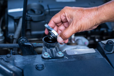 Cropped hands of man repairing car engine
