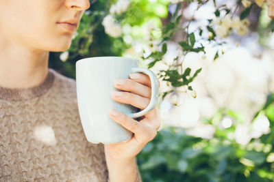 Midsection of woman holding coffee cup