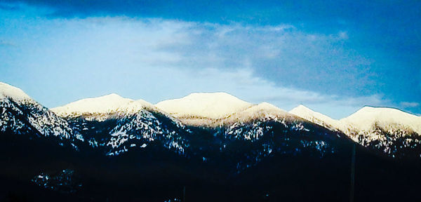 Scenic view of mountains against cloudy sky