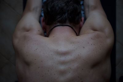 Directly above shot of shirtless man stretching at home