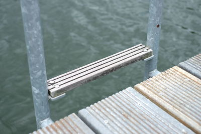 High angle view of plank on metallic poles over boardwalk against sea