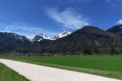 Scenic view of field and mountains against sky