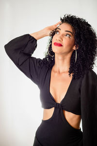 Young beautiful smiling woman with her hand in her hair. looking up.