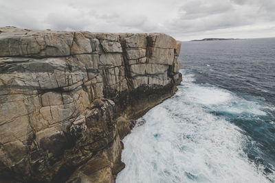 Rock formations by sea against sky