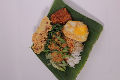 High angle view of chopped vegetables on plate against white background