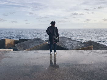 Rear view of a man overlooking sea