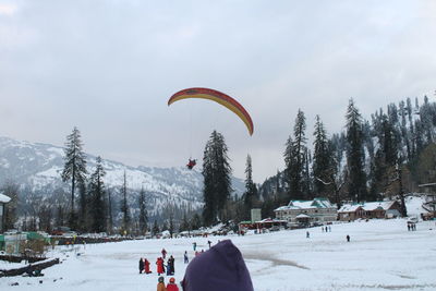 People on snowy field against sky