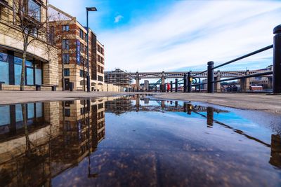 Reflection in city against sky