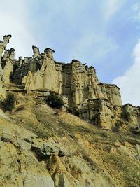 Low angle view of rock formations against sky