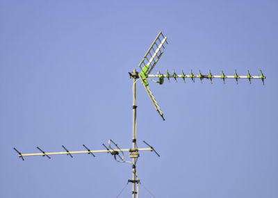 Low angle view of wind turbine against clear blue sky