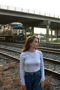 Rear view of young woman standing on railroad station