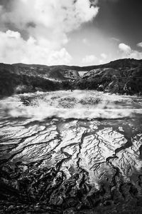 Scenic view of hot spring against sky