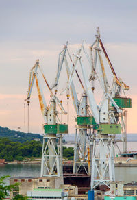 Cranes at construction site against sky