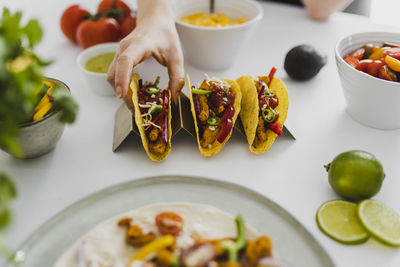 Person taking mexican taco from tray