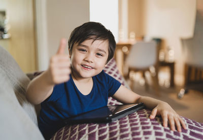 Portrait of boy using mobile phone at home