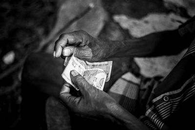 Midsection of man holding paper currency