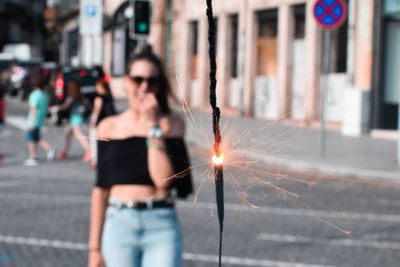 Blurred motion of woman standing on street in city