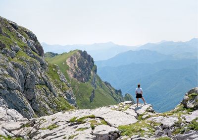 Rear view of man looking at mountain against sky