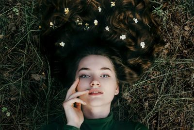 Portrait of young woman lying on grass