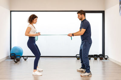 Side view of man and woman standing against wall