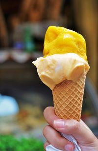 Close-up of hand holding ice cream cone