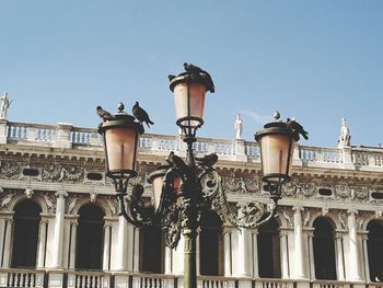 Low angle view of street light against building