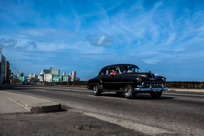 Vintage car on road against sky