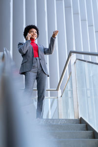 A young african-american businesswoman wearing a red turtleneck and a suit in a business building