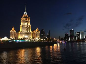 Illuminated buildings in city at waterfront